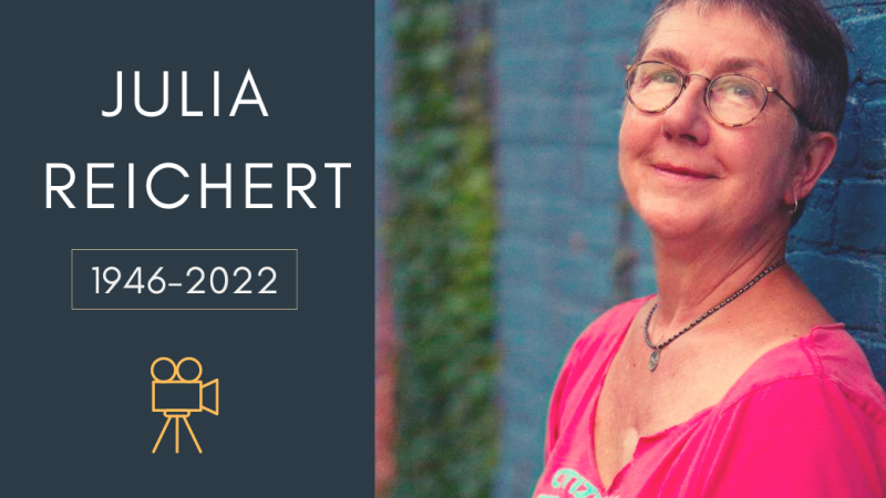 Text reads julia reichert 1946-2022 with an icon of a camera underneath with a photo on the right of a white woman with cropped hair wearing glasses and a pink top against a blue wal