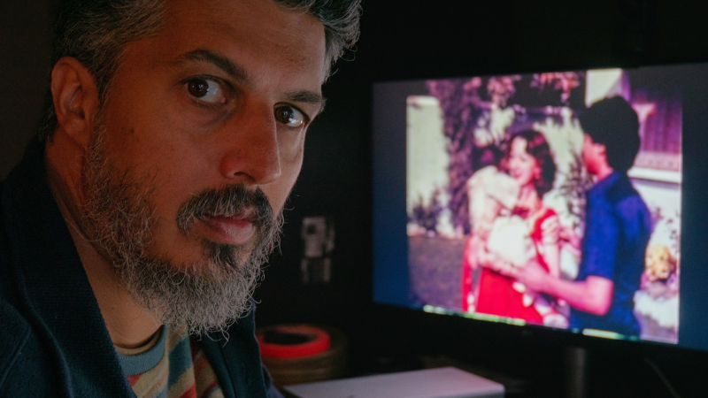 Director Sifian Khan looks at the camera with a television on the background.