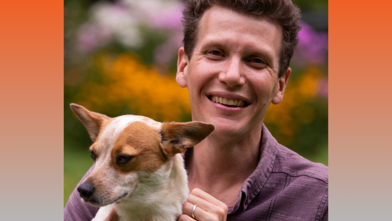 Photo of Brad Heck looking at the camera and holding a small dog.