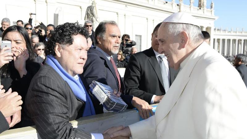 Filmmaker Luis Argueta hands Pope Francis DVDs of his documentary, abUSed: The Postville Raid.