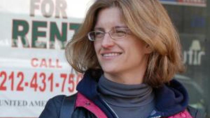 Filmmaker Kelly Anderson outside with a "Store for Rent" sign in the window behind her.