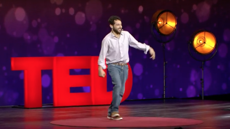 Filmmaker Reid Davenport walks onto the stage to present a TED Talk.
