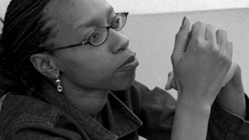 A young Black woman sits, listening intently.