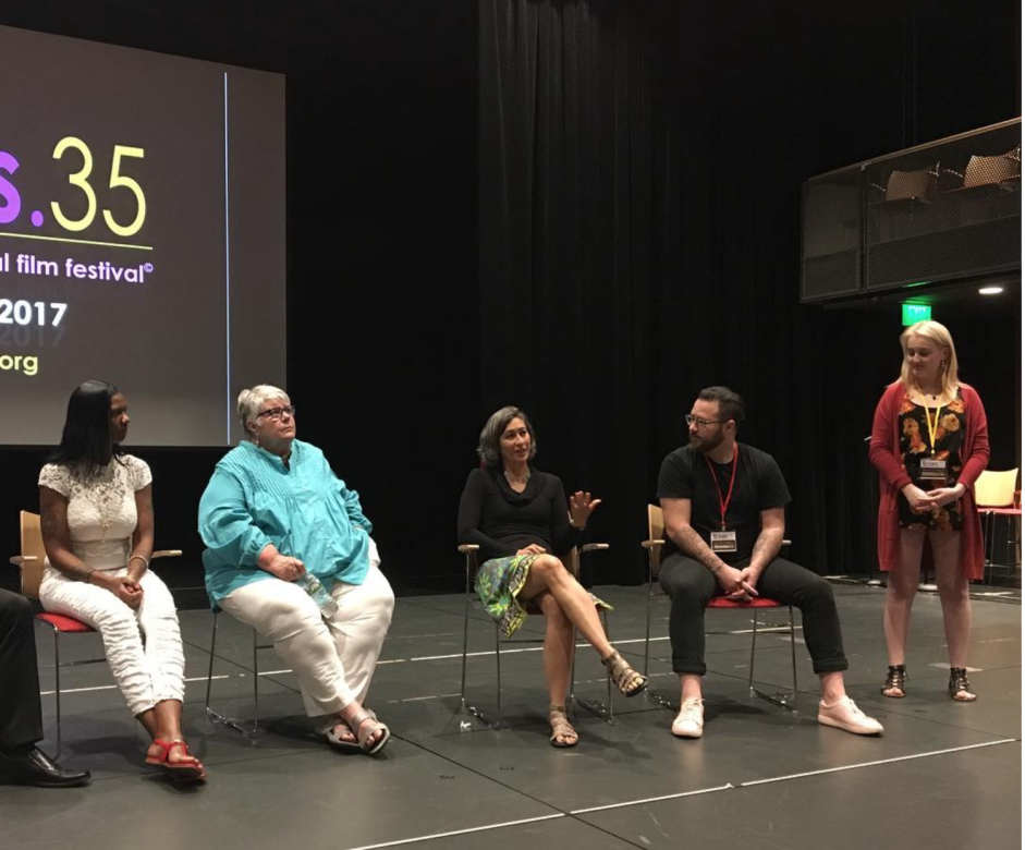 Filmmaker Julie Mallozzi presents onstage at a screening. Sitting beside her are people from the film Circle Up and others working in restorative justice.