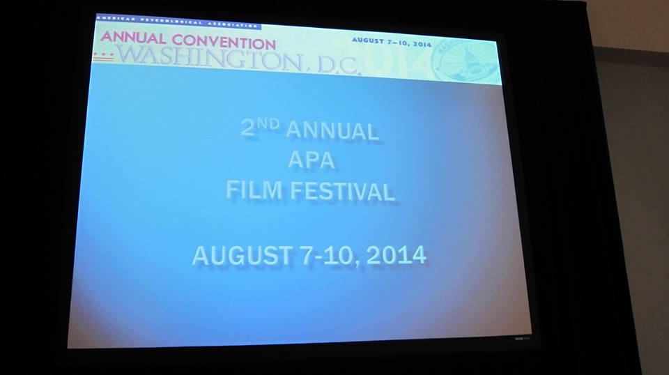 A large screen with the words “Annual Convention Washington D.C.” at the top and reading “2nd Annual APA Film Festival August 7-10, 2014” in the center of the screen.