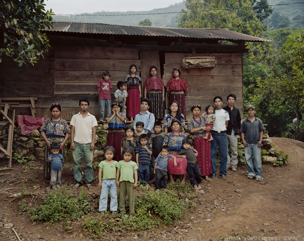Caba family of adults and children standing in front of a house