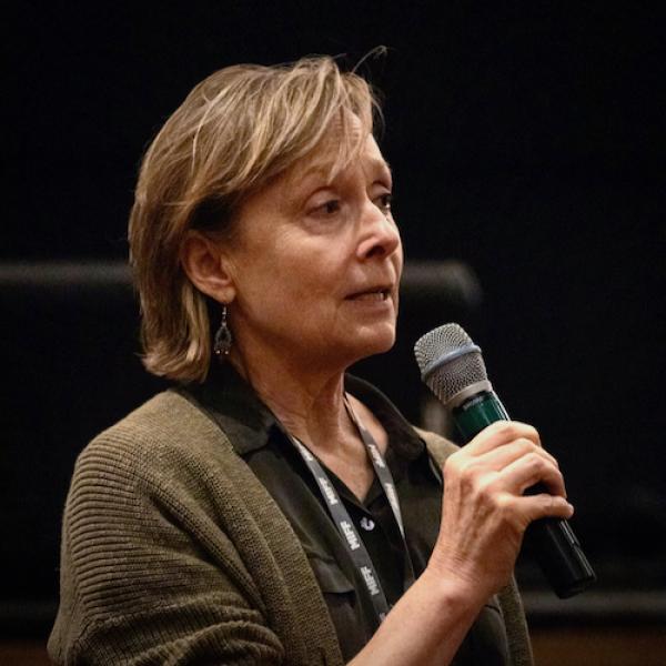 Female filmmaker speaking, holding microphone 