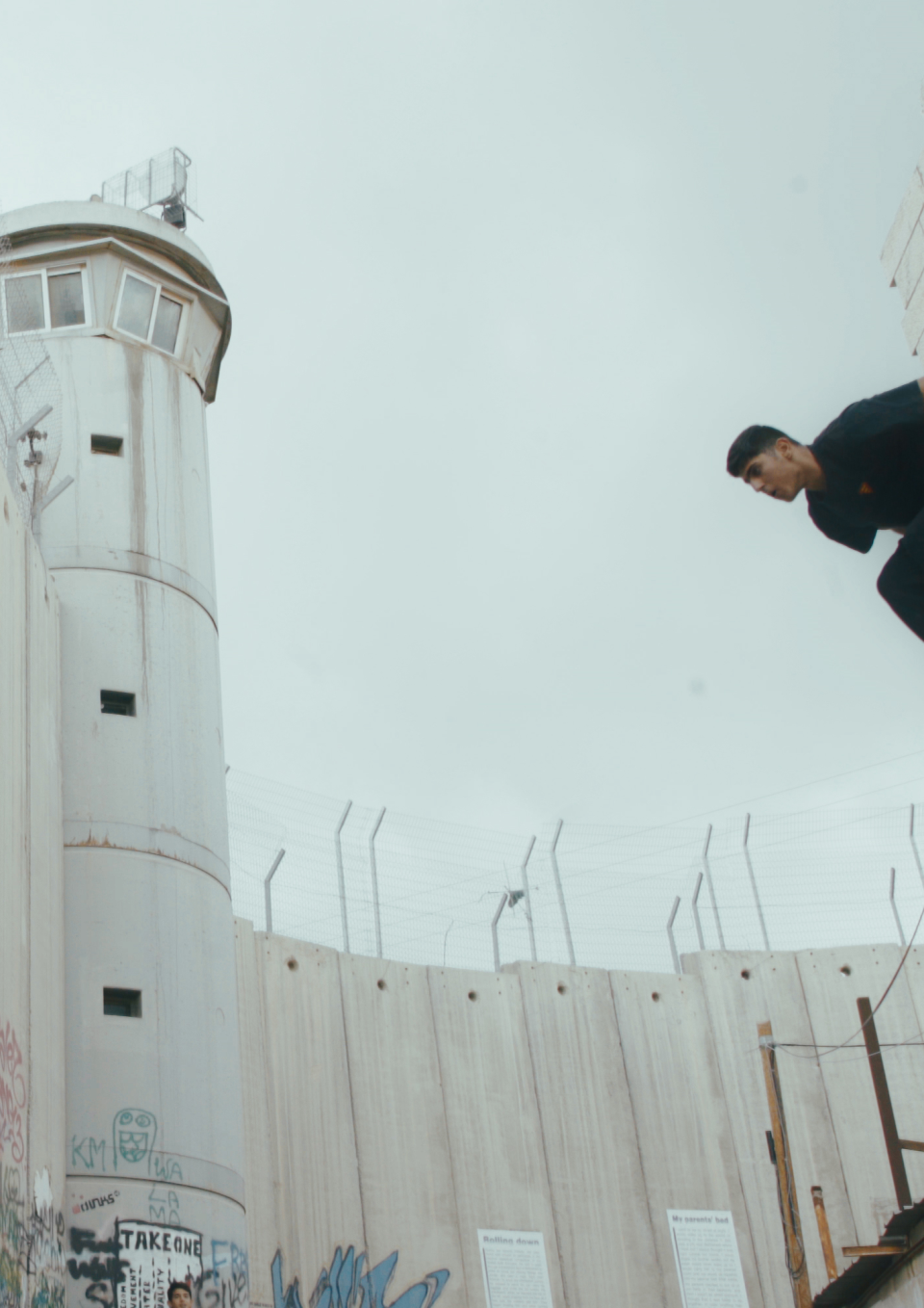 A young Palestinian man about to jump from one building to another.