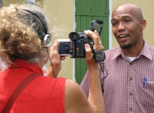 Filmmaker Andrea Leland is holding camera pointed at Carib subject 