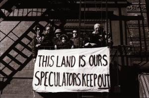 People on fire escape holding banner