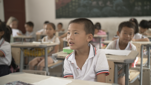 A group of Chinese youth sit at their desks during class time.