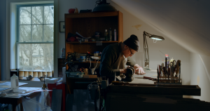 Brain Cohen bent over the desk in his studio working on etchings.