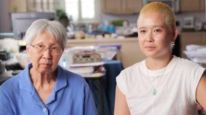 A young person sits next to their elder