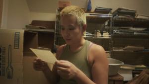 Young person in an attic reading a letter