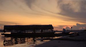 A fishing boat on a river in the Amazon region at sunset