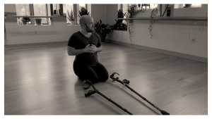 Production Still - Black and white photo of dancer Toby sitting on heels with crutches on floor