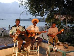 Blinky, Jamesie & Derby sitting with their back to the ocean, playing music 