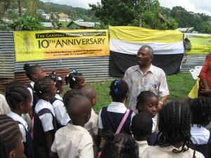 Dr Colin Gill speaking to a group of children, teaching them a Garifuna word. 