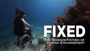 A still from the New Day film Fixed: The Science of Human Enhancement. A woman in a wheelchair is scuba diving. She floats slightly above the ocean floor. Her arms are bare and she does not appear to be wearing full scuba gear other than small goggles. Her hair drifts up in the water and she holds her arms out to the side for balance.