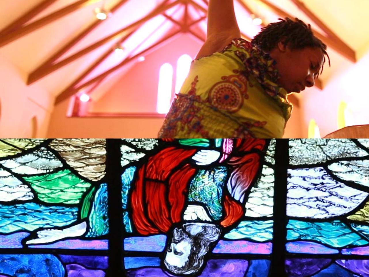 A split image where the top half is a black person from the ribcage up with their arm in the air reaching toward the beams of a vaulted ceiling. The bottom half is an upside down stained glass image of a white Jesus with a red garment against a blue and purple background.