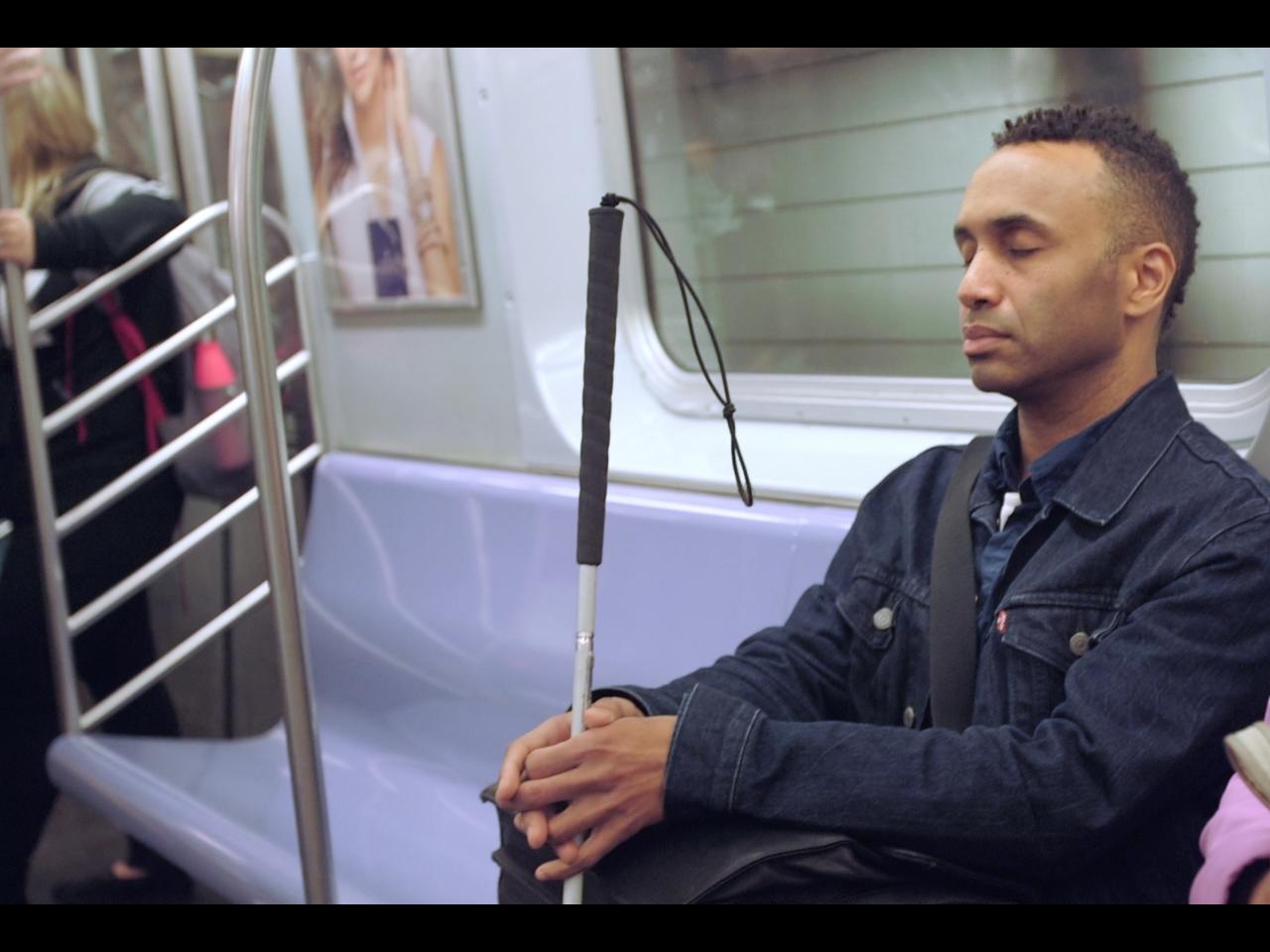 blind man with cane on subway