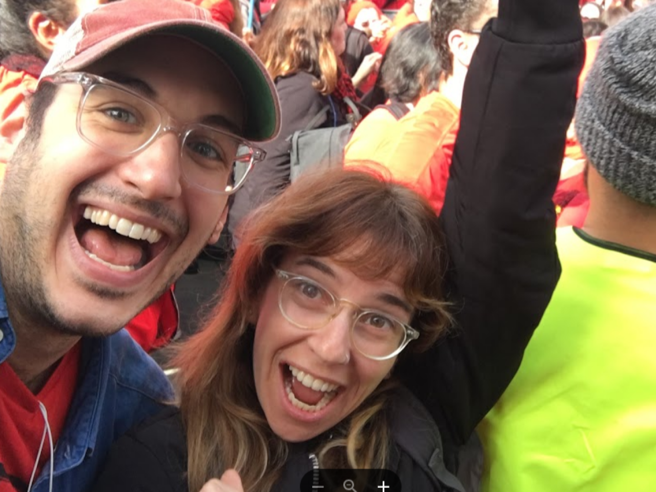A selfie of filmmakers Yael Bridge and Yoni Golijov at a big, crowded event. Yael's arm is raised high over head in celebration, and they both have big smiles.