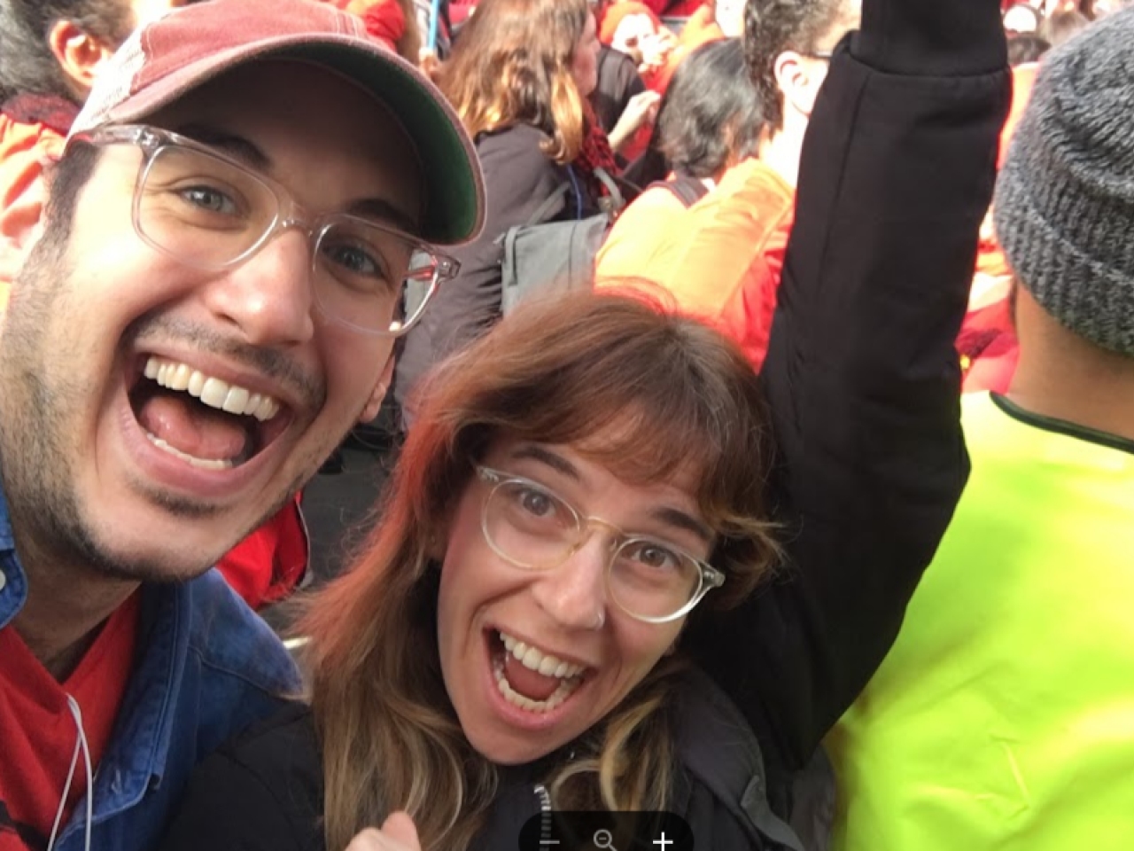 Filmmakers Yael Bridge and Yoni Golijov look up at the camera. They have big smiles and glasses.