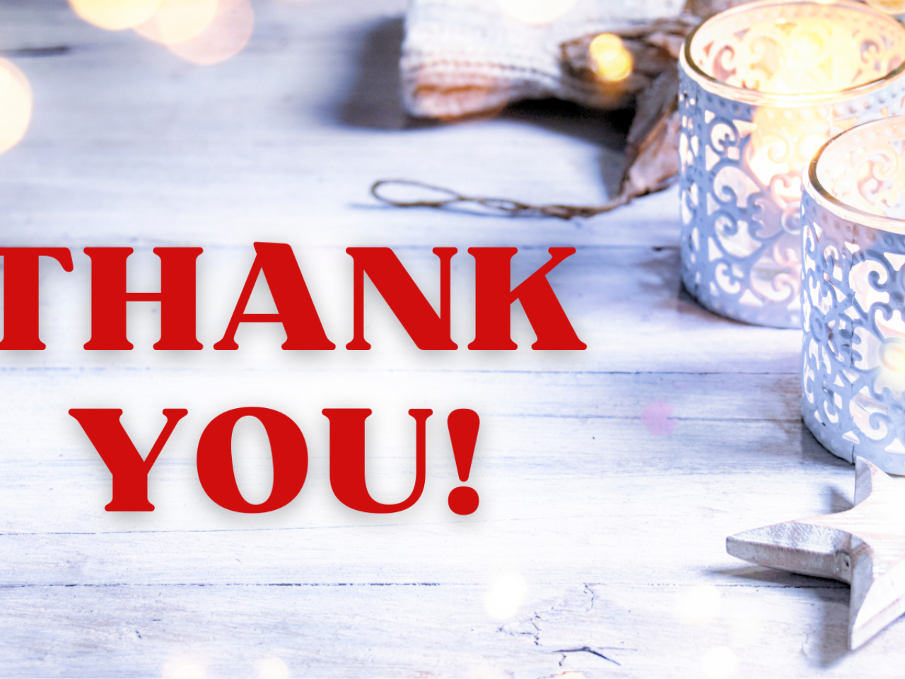 Thank you text over whitewashed wood background with white candles and star ornament