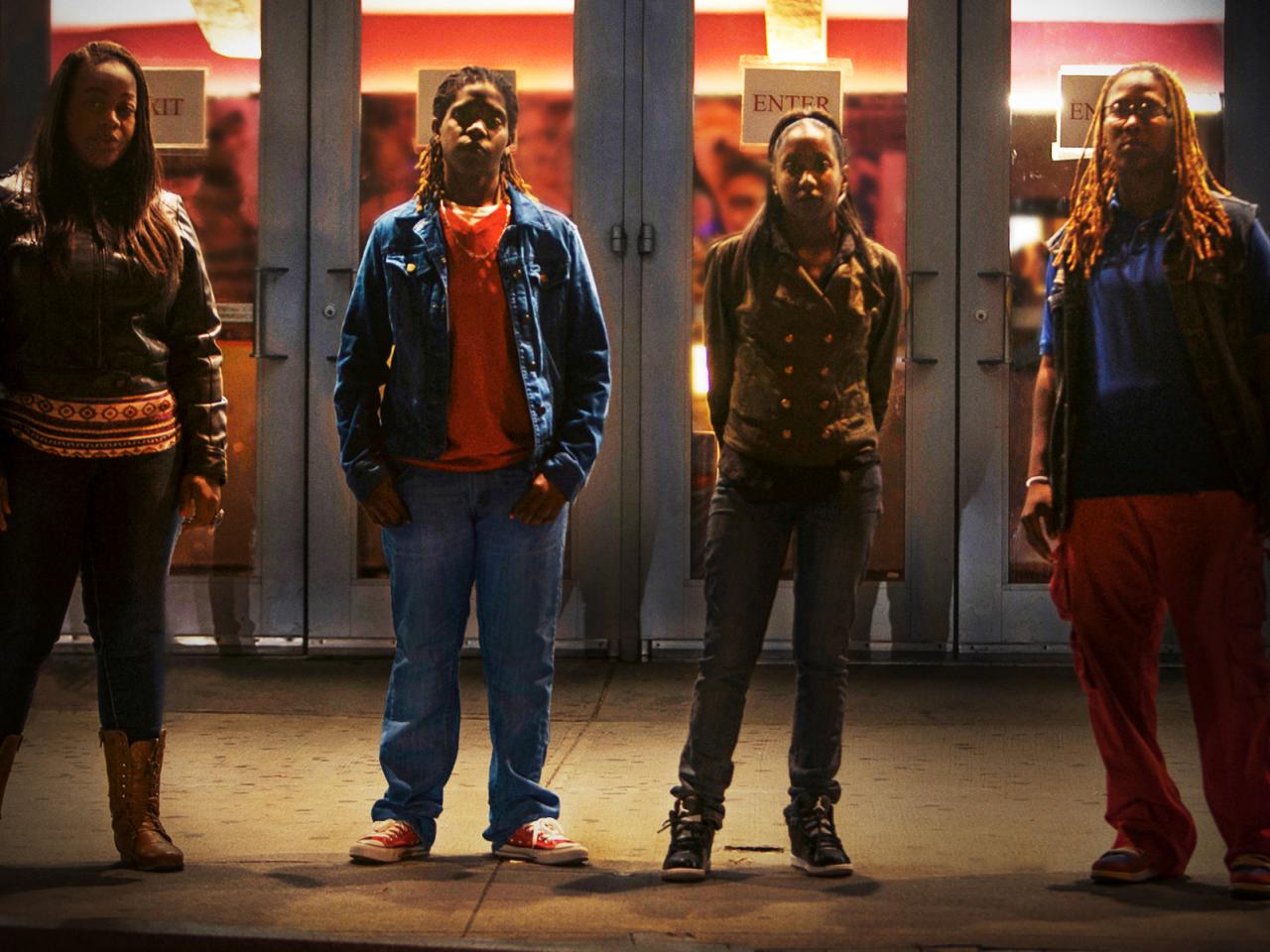 Four African American teenage girls at night in front of doors