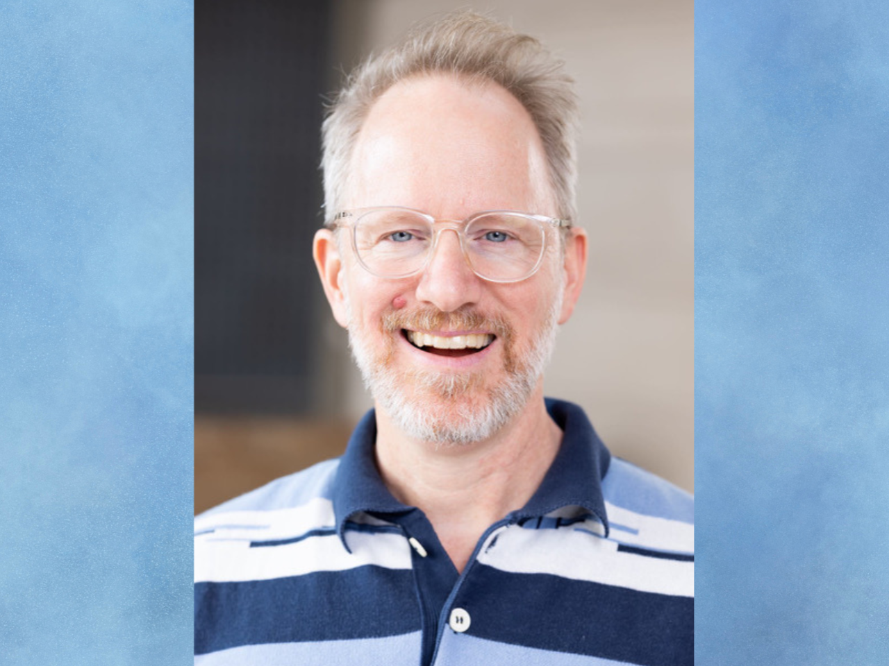 Headshot of filmmaker Kyle Henry, a white man with a graying blond beard and clear-framed glasses, smiling for the camera.