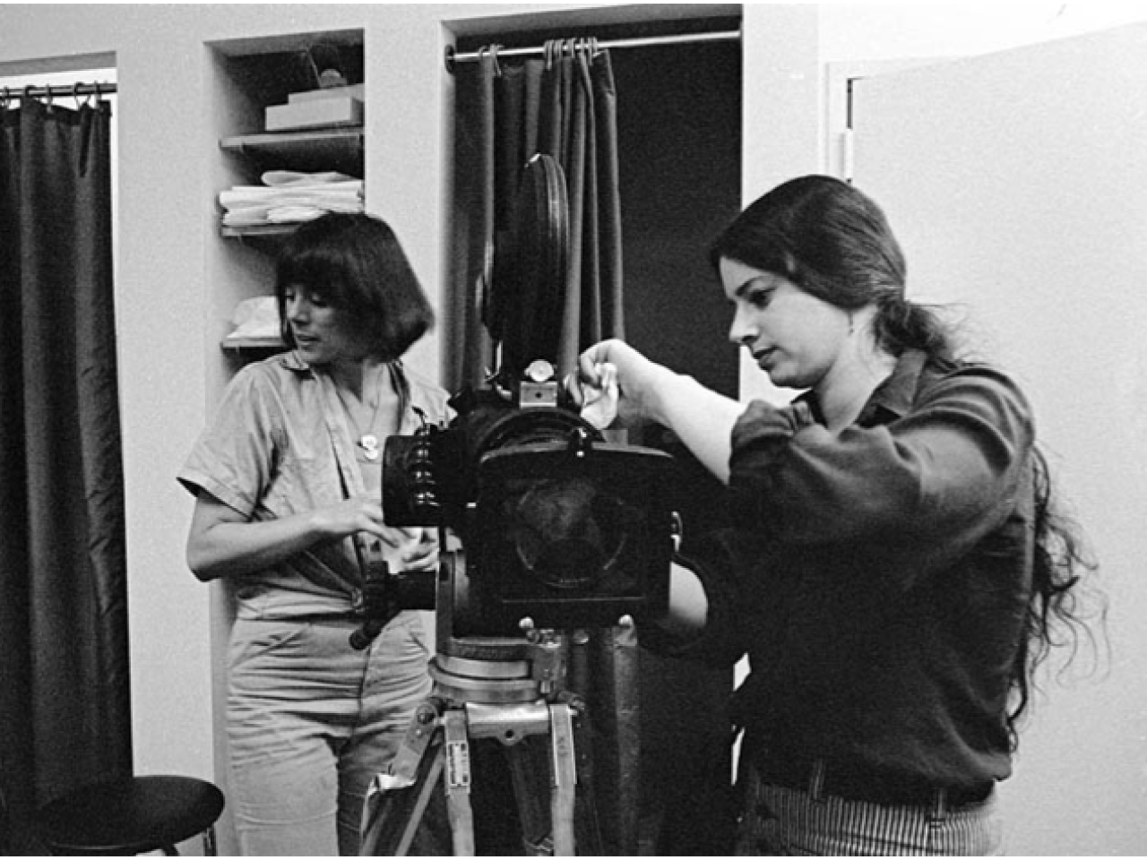 Black and white photo of Amalie Rothschild working on her video camera on an all-women set in the 1970s.