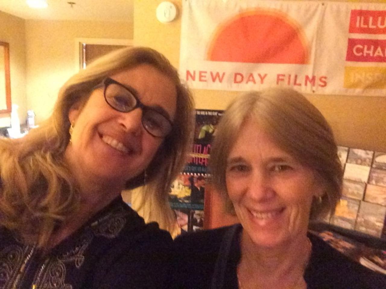 Filmmakers in front of the New Day Films exhibition table smiling for the camera.