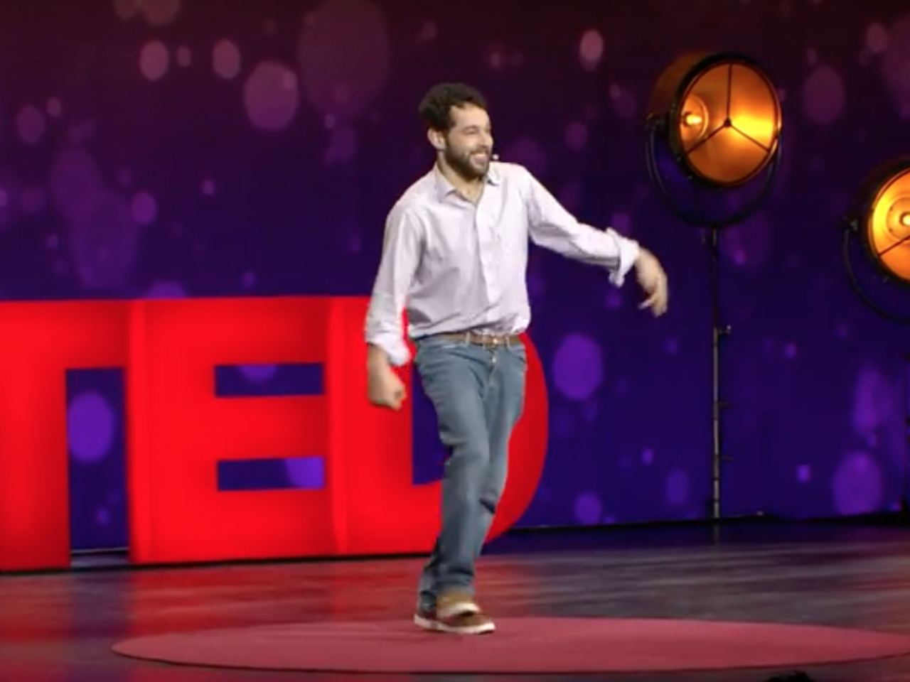 Filmmaker Reid Davenport walks onto the stage to present a TED Talk.